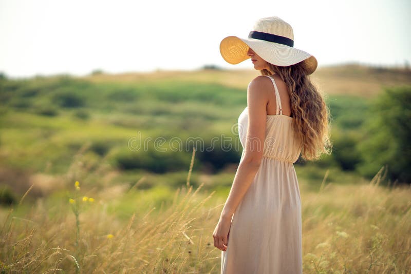 Back View of Beautiful Woman Who Walks on Field while Wearing a Sunhat ...