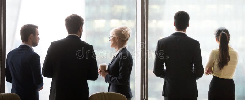 Back view of colleagues standing near window enjoying coffee bre stock photos Back view of colleagues standing near window enjoying coffee bre stock photos