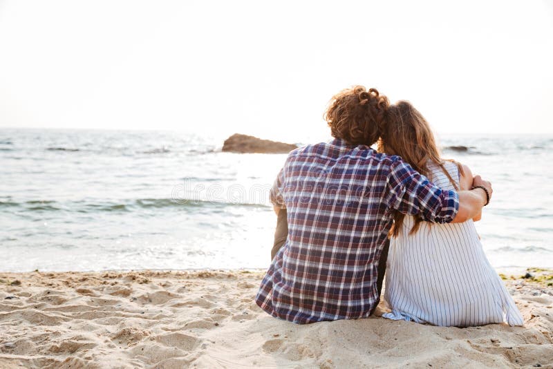 Back View of Couple Sitting and Relaxing on the Beach Stock Image ...