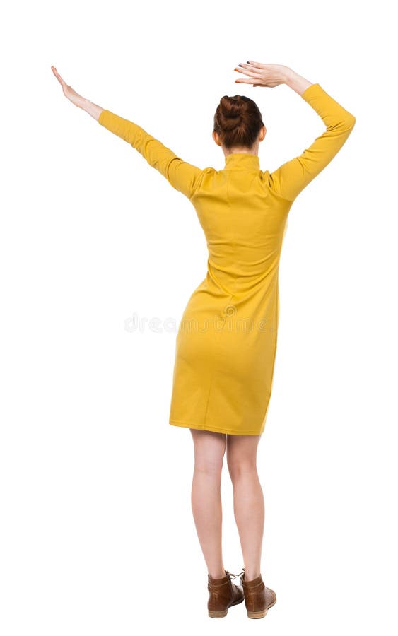 Back view of dancing young beautiful woman in dress.