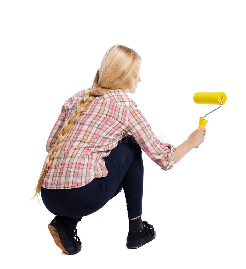 Back view of a girl who paints the paint roller. rear view people collection. backside view of person. Isolated over white background. Squatting woman paints the wall roller