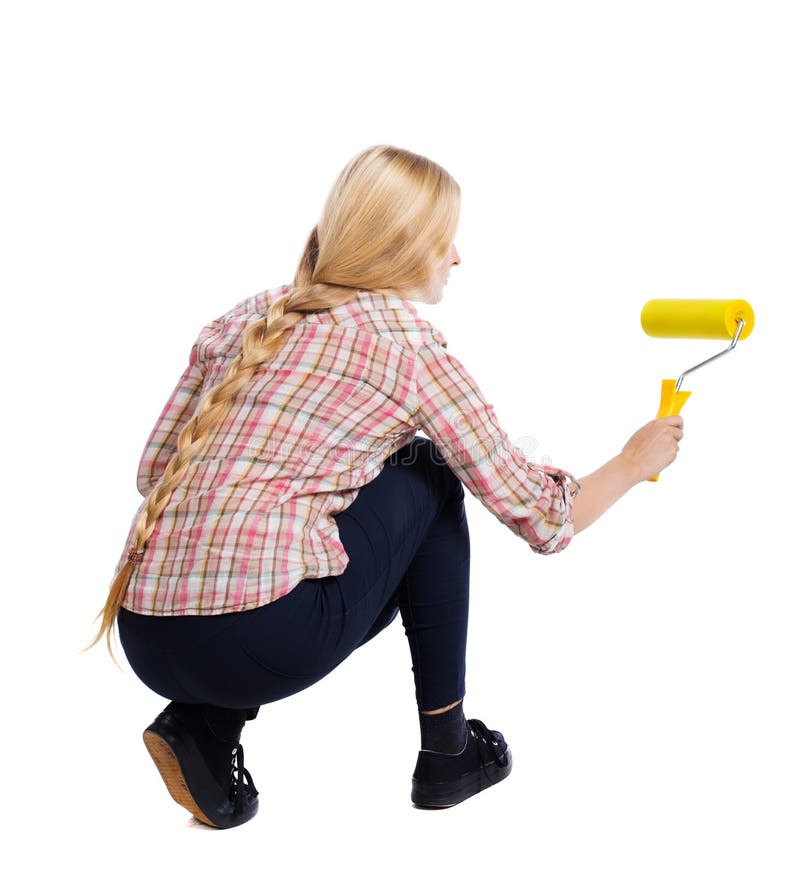 Back view of a girl who paints the paint roller. rear view people collection. backside view of person. Isolated over white background. Squatting woman paints the wall roller.