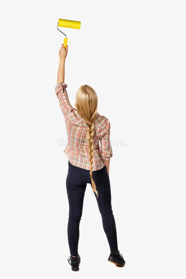 Back view of a girl who paints the paint roller. rear view people collection. backside view of person. Isolated over white background. Blonde girl in a checkered shirt paints the wall.