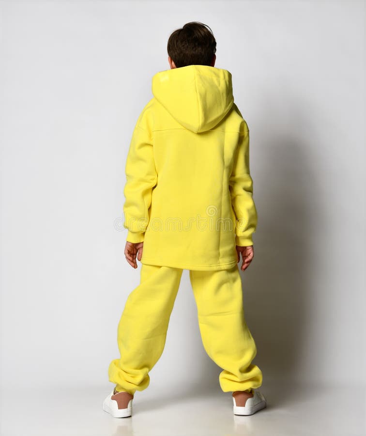 Back View of a Guy in a Bright Yellow Tracksuit with a Hood, on a Light ...