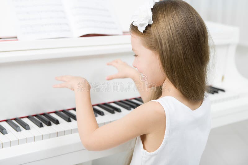 Look she plays the piano. Девочка за белым роялем. Девочка в белом платье играет на пианино. Маленькая девочка за роялем. Маленькая девочка за пианино.