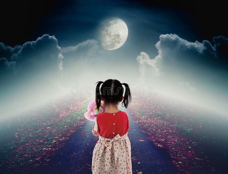 Back view of lonely child with doll sad gesture on pathway with