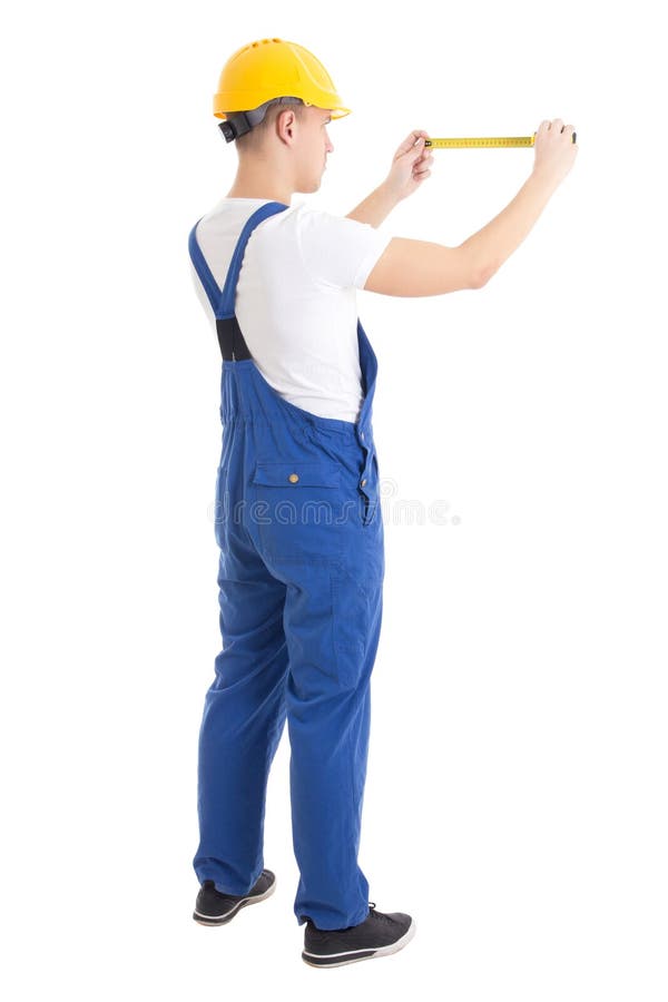 Back view of man builder in blue uniform holding measure tape is royalty free stock image