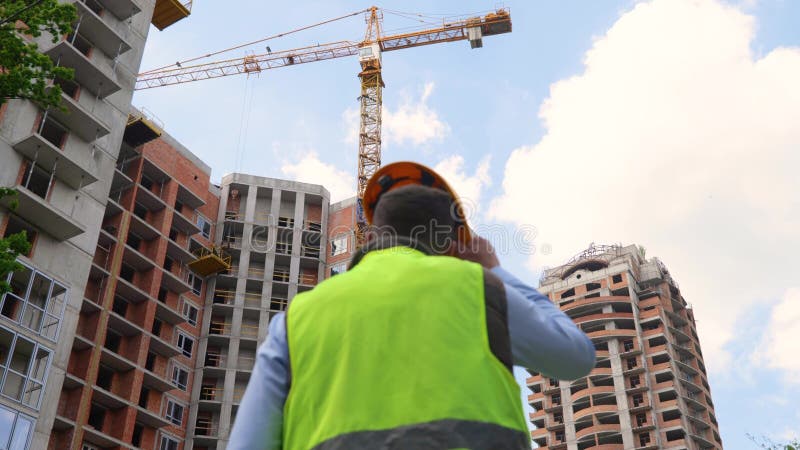 Back View of Man Builder in Uniform Standing in Front of Construction ...