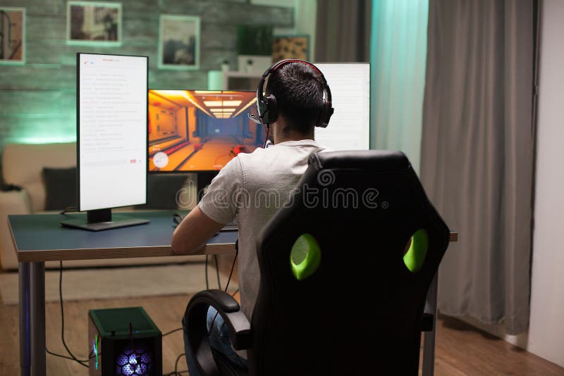 Premium Photo  Rear view play video computer pc. young man sitting on  chair in game station. happiness streamer indian man wearing headphone playing  game online in the darkroom.