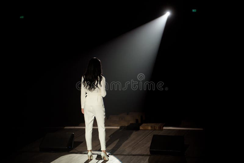 Back View of a Singer with Microphone Singing a Song on Stage in White ...