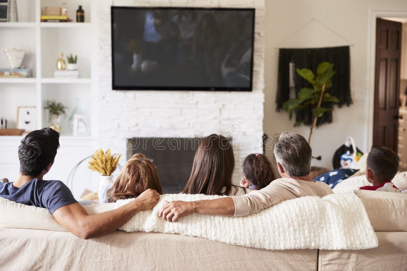 De tres generaciones Hispano familia sobre el sofá seguimiento televisión.