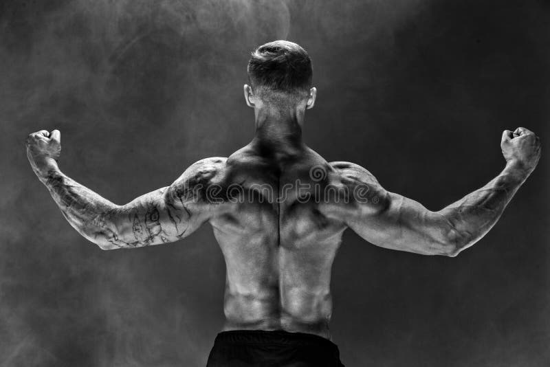 Back View of Unrecognizable Man, Strong Muscles Posing with Arms Down in Smoke. Stock Photo - Image of muscular, fitness: 165406574 Back View of Unrecognizable Man, Strong Muscles Posing with Arms Down in Smoke. Stock Photo - Image of muscular, fitness: 165406574