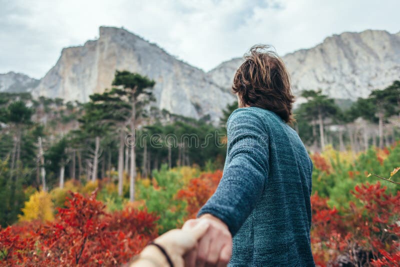 Man traveling in autumn forest by the mountain