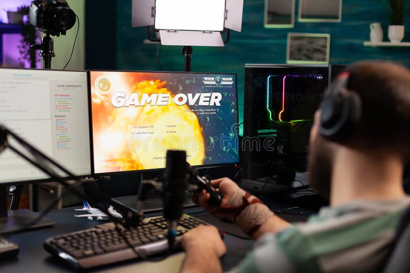 Back shot of pro gamer playing online shooter game on computer using  wireless controller. Competitive player man winning videogame tournament  use professional equipment at home gamming studio Stock Photo - Alamy