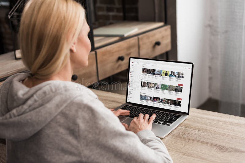 back view of woman using laptop with youtube website