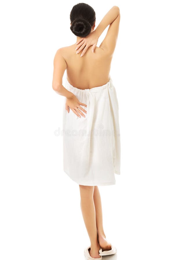 Back view woman wrapped in towel touching her back royalty free stock photos