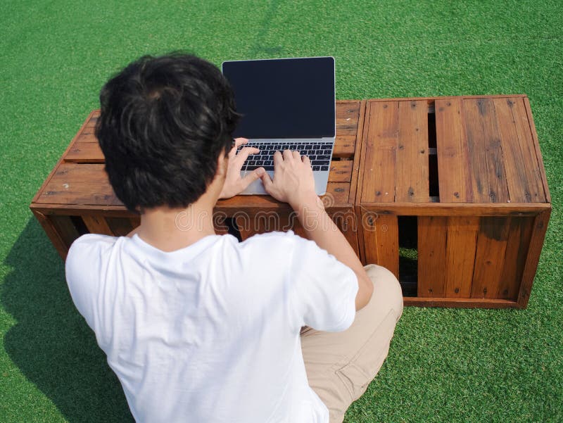 Back view of young Asian man using computer laptop at outdoors. stock images Back view of young Asian man using computer laptop at outdoors. stock images