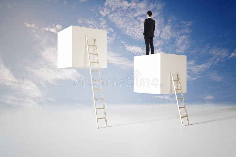 Back view of young businessman standing on abstract cubes with ladder on bright blue sky background, Career, growth and success royalty free stock image