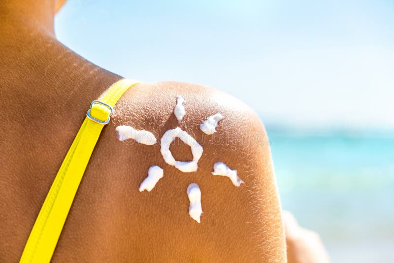 Back View of Young Woman Tanning at the Beach with Sunscreen Cream
