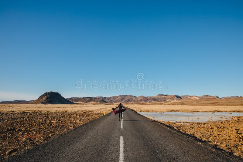 back view of young woman walking in asphalt road in iceland, reykjanes stock images back view of young woman walking in asphalt road in iceland, reykjanes stock images