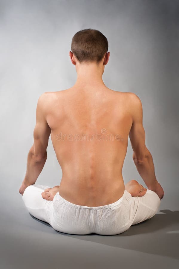 Back of young man in yoga position