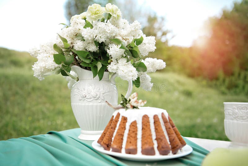 Backen Sie mit einigen Schalen auf dem Picknicktisch zusammen, der mit Blumen, Kerzen, Vase auf dem grünen Gebiet verziert wird stockbilder Backen Sie mit einigen Schalen auf dem Picknicktisch zusammen, der mit Blumen, Kerzen, Vase auf dem grünen Gebiet verziert wird stockbilder