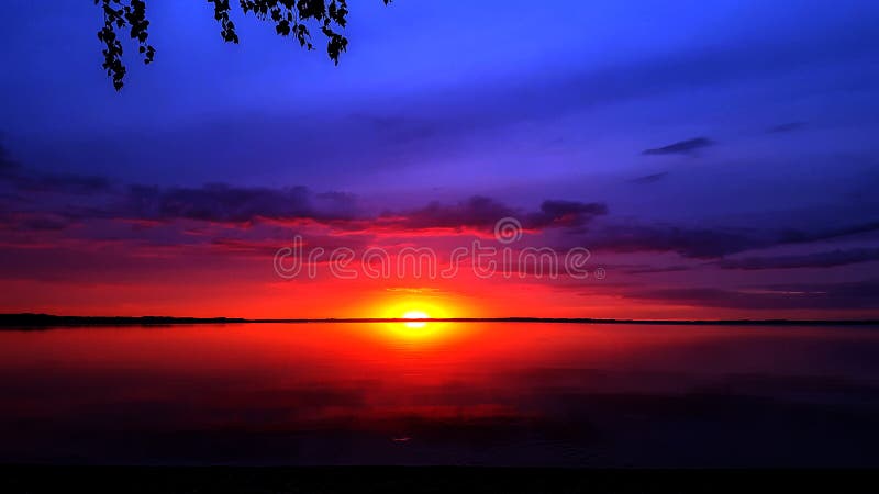 Background with abstract colorful violet pink sunset sun and cloudy sky reflecting in Razna lake water, Latvia