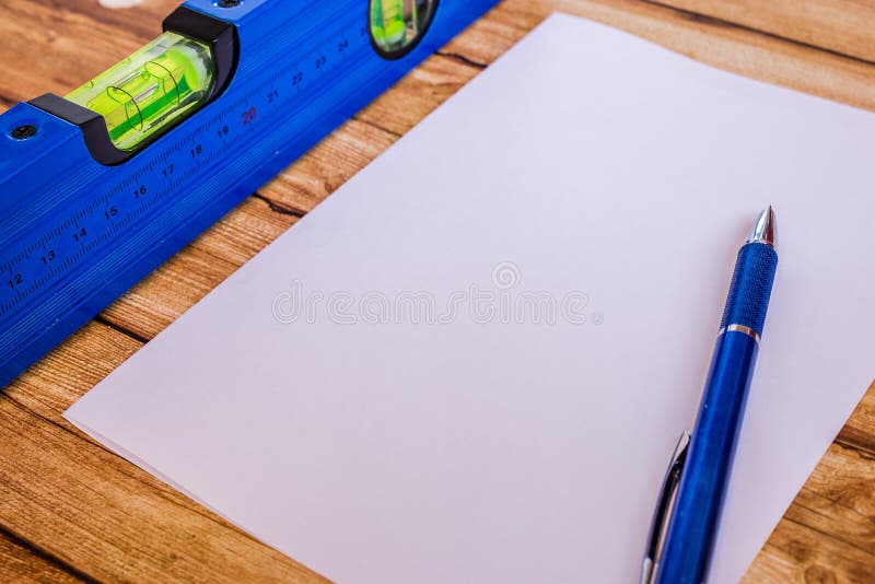 Background blue building level and a sheet of paper