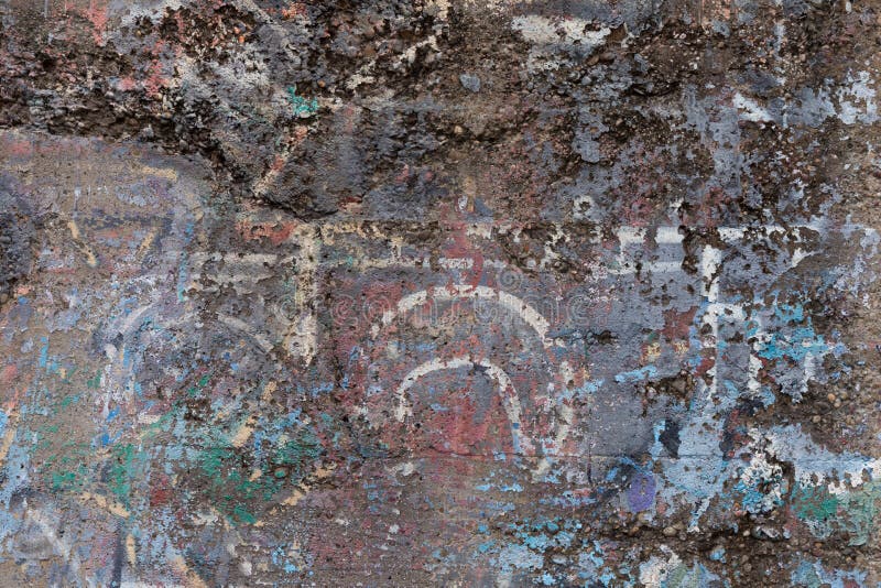 Background of crumbling concrete aggregate wall with multiple layers of paint, industrial textures royalty free stock photos