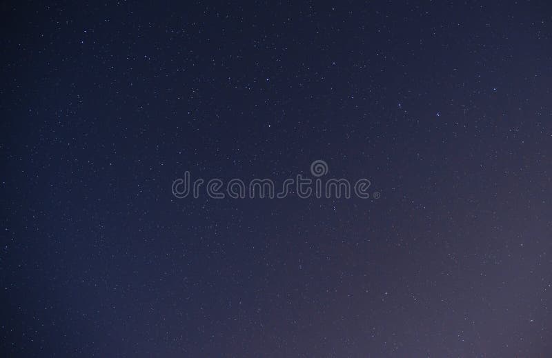 Background of dark-blue night sky with countless twinkle stars and moving white clouds upon on it