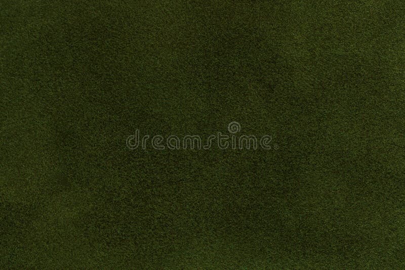 Background of dark green suede fabric closeup. Velvet matt texture of olive nubuck textile