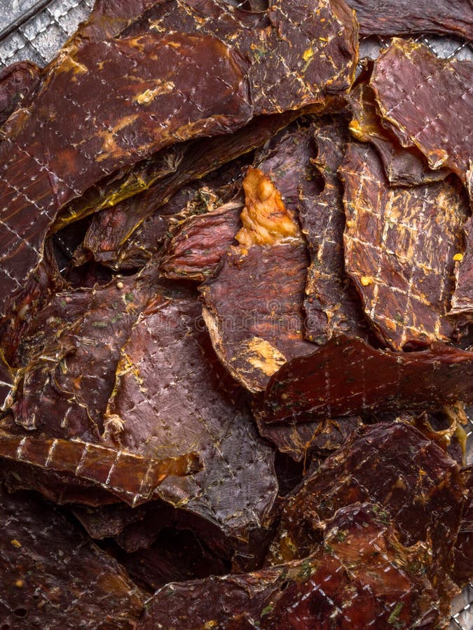 Dried or Dehydrated Meat Slices with Spices in Jars, on Wooden