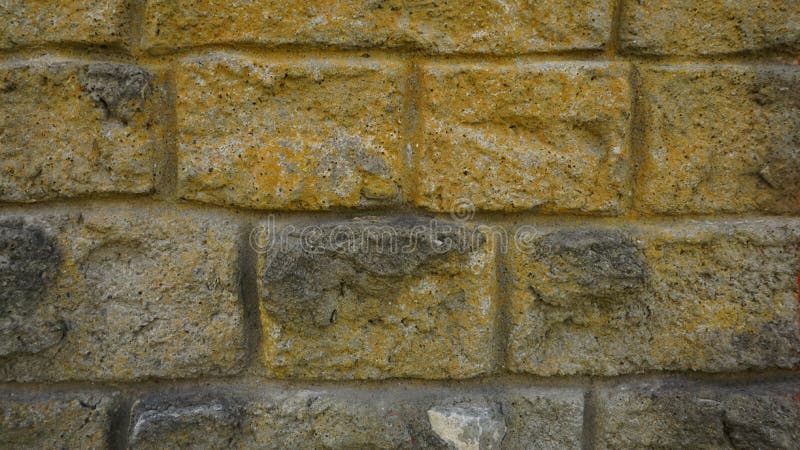Background a fragment of very old wall from the end th century made white and gray rectangular stones with yellow coating an large stock afbeeldingen