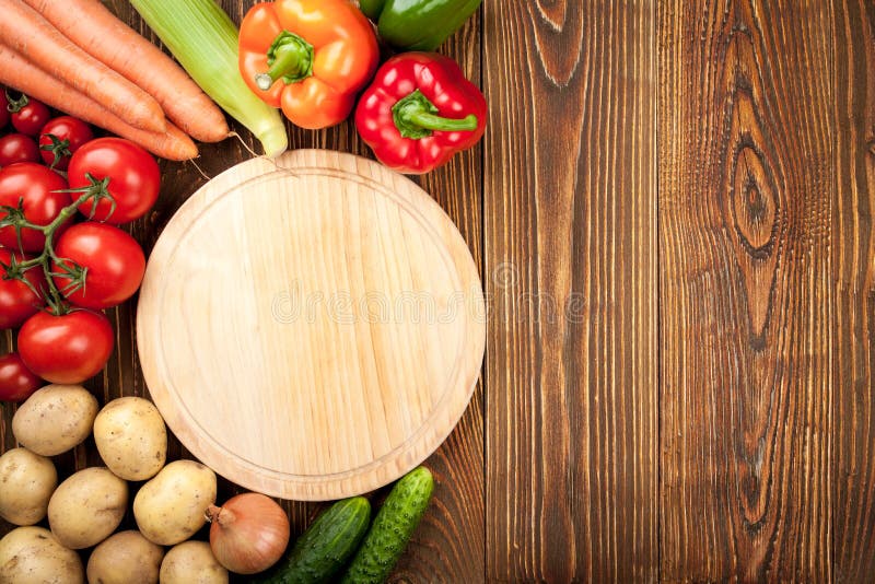 Background of Fresh Raw Vegetables and Cutting Board Stock Photo