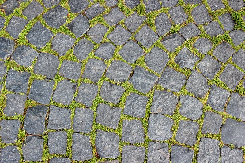 Background of granite pavers and green grass makes its way between stones. Background of granite pavers and green grass makes its way between the stones royalty free stock images Background of granite pavers and green grass makes its way between stones. Background of granite pavers and green grass makes its way between the stones royalty free stock images