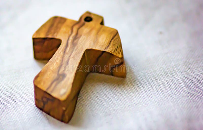 Background, image of a small wooden cross laid on linen fabric used as a pendant by some faithful. stock images