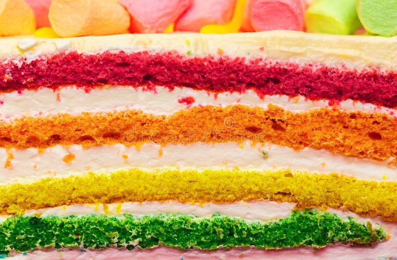 Background of multicolor four layer cake with colored marshmallow on the top. Close up. Rainbow cake texture royalty free stock images