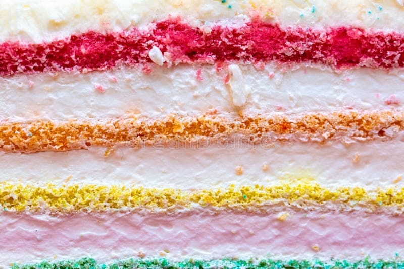 Background of multicolor four layer cake with colored marshmallow on the top. Close up. Rainbow cake texture stock images