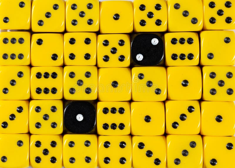 Background of random ordered yellow dices with two black cubes stock photo