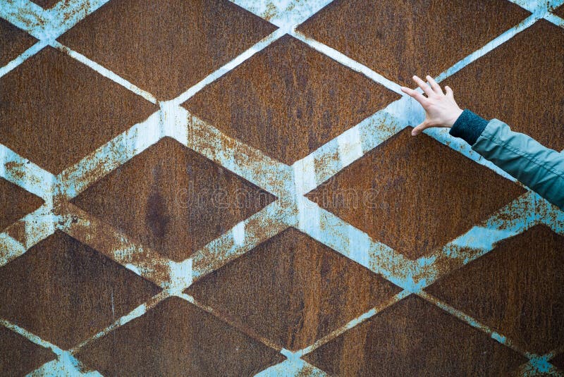 Background of rusted vintage metal with a diamond pattern and vintage blue paint and a slender open female hand stock photos Background of rusted vintage metal with a diamond pattern and vintage blue paint and a slender open female hand stock photos