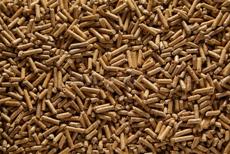 Background texture of renewable compressed wood pellets for use in household heating, barbecue or in the garden as a mulch around plants. Background texture of renewable compressed wood pellets for use in household heating, barbecue or in the garden as a mulch around plants