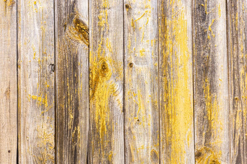 Background of their worn old planks with traces of yellow paint