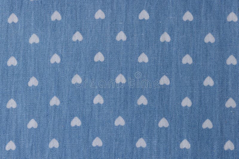 Background of white drawings of hearts on blue fabric background royalty free stock photography
