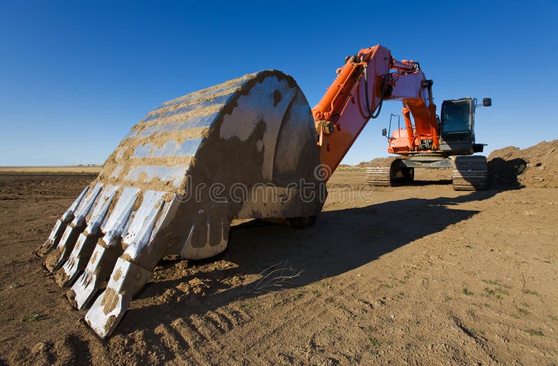 A large orange backhoe parked at a construction site. Claw machine stock images, royalty-free photos and pictures