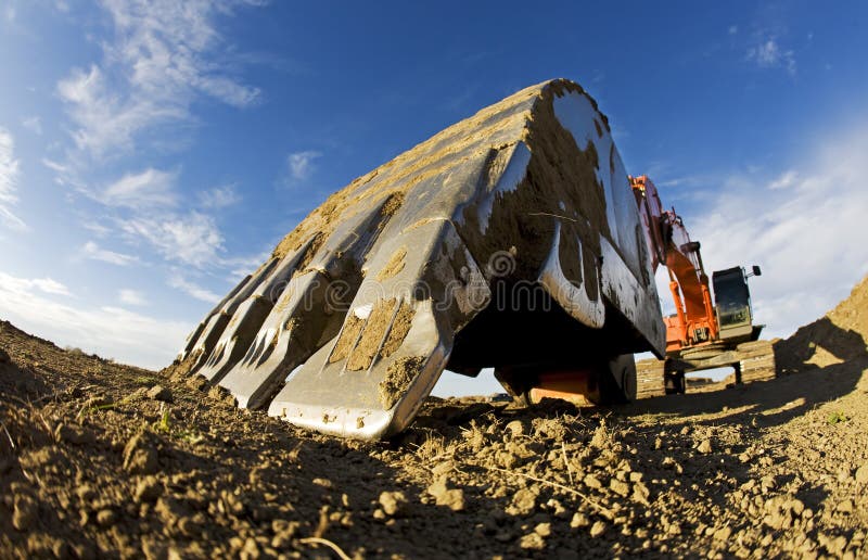 A Large orange backhoe at a construction site, fish eye closeup. Claw machine stock images, royalty-free photos and pictures