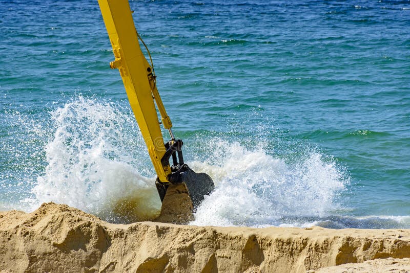 Backhoe que remove a areia da praia fotos de stock