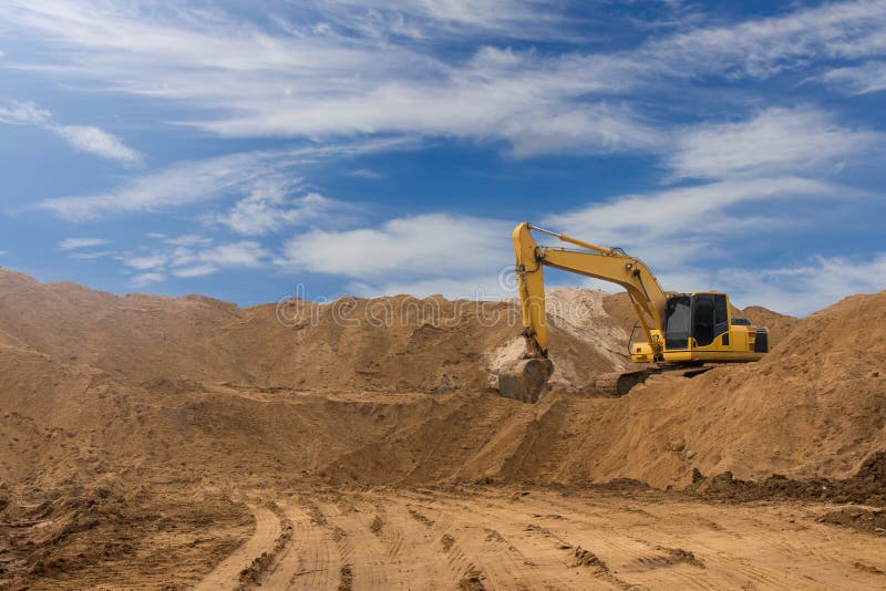 Backhoe on the sand against the sky.