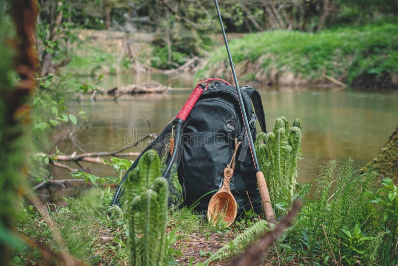 Backpack and Fishing Rod on the River. Fishing Gear Stock Photo Image