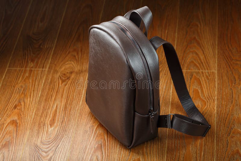 Backpack made of brown genuine leather on a wooden background