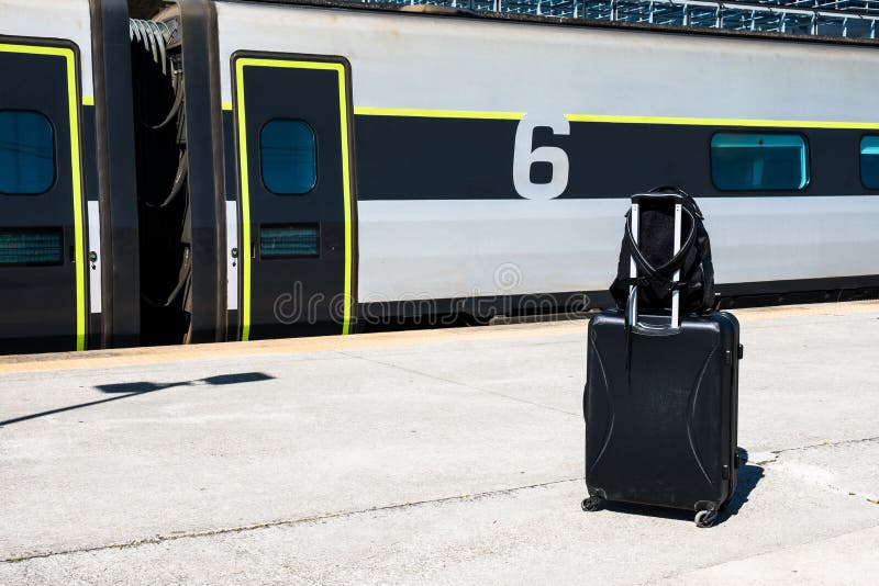 Backpack and Suitcase with Wheels at the Train Station. Baggage while
